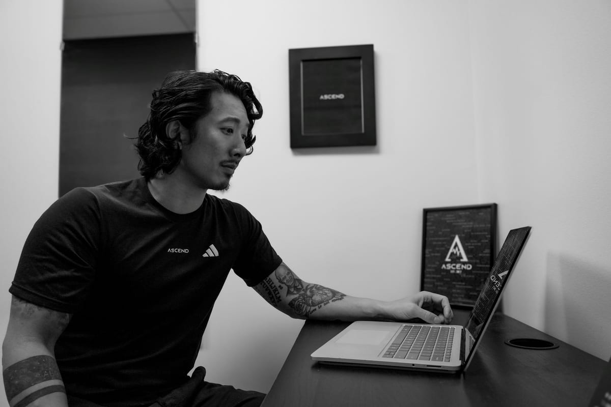 An ASCEND practitioner at the clinic desk, under the ASCEND wall mark